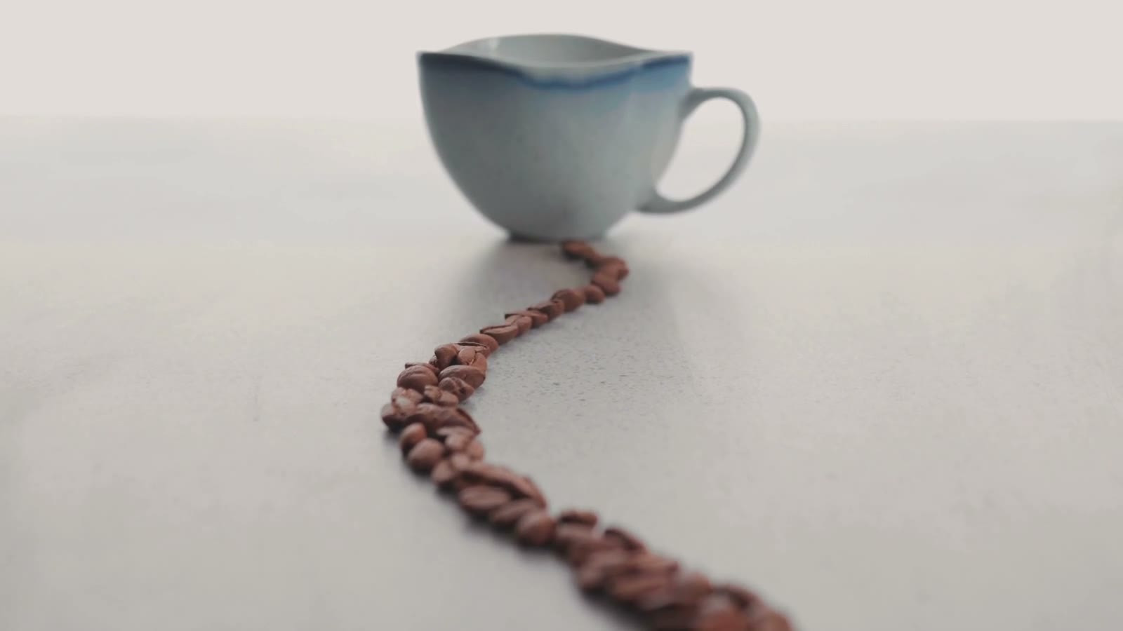Un chemin de grains de café qui mène à une tasse.