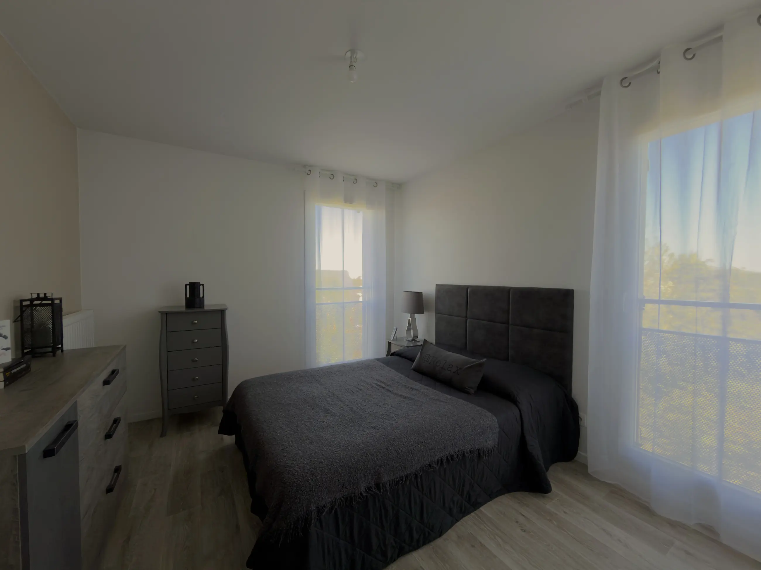 La grande chambre vue depuis l'autre angle, ses deux fenêtres.