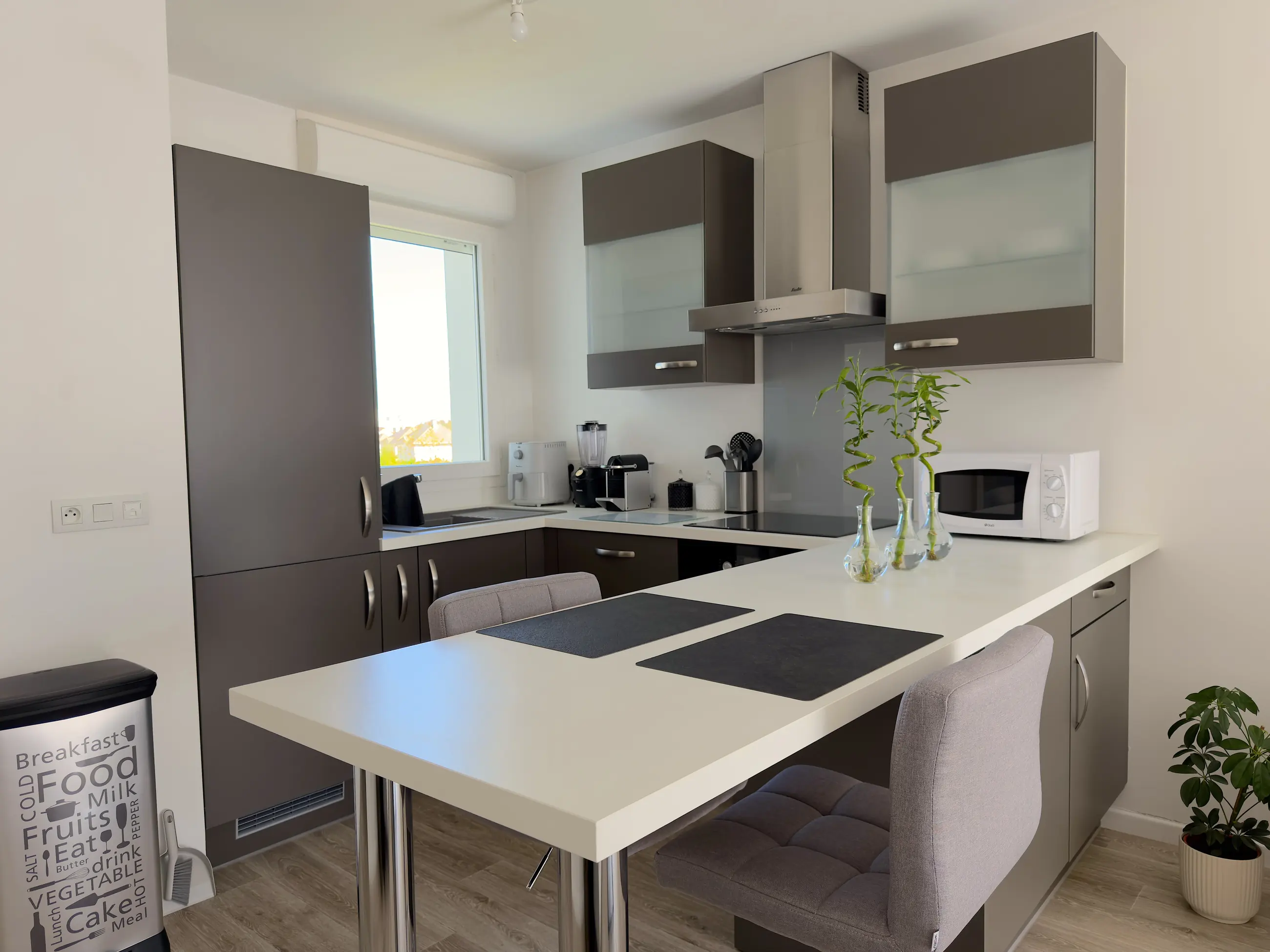 La cuisine aménagée et équipée, avec son plan de travail et sa table haute.