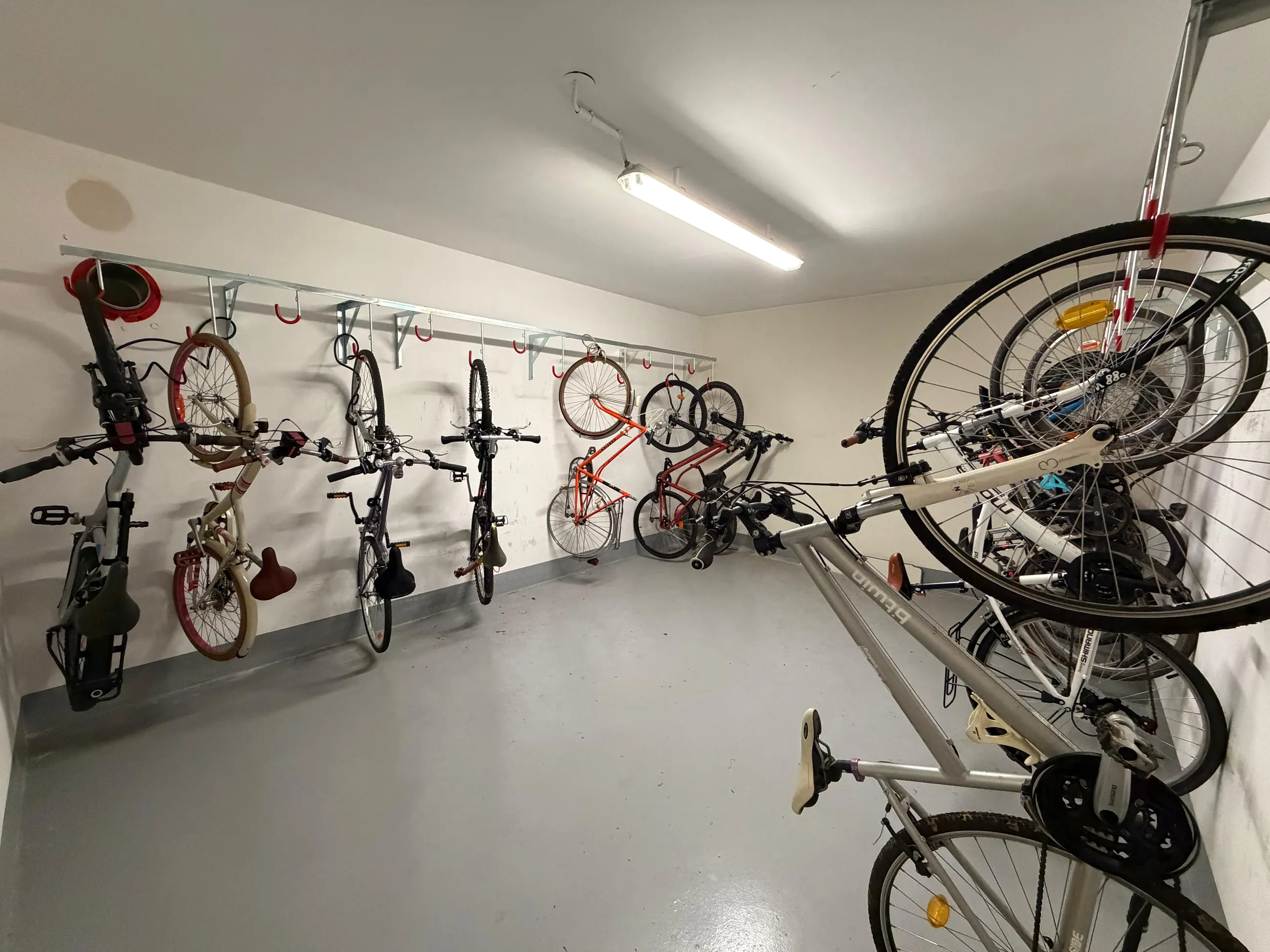 Le local à vélos commun de la résidence, avec ses supports muraux.